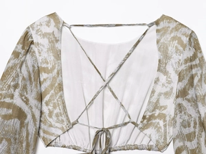 Detalle de blusa floral con tirantes cruzados en espalda y cintura elástica