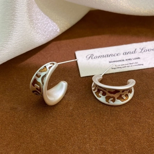 Detailed close-up of C-shaped leopard pattern earrings with 925 silver hallmark