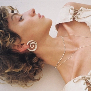 Élégantes boucles d'oreilles spirales en acier 18k et collier tennis sur un mannequin