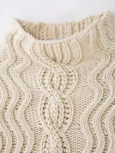 Close-up of cream Fair Isle knit sweater showing cable stitch details and turtleneck collar
