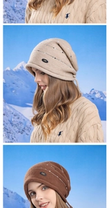 Détail du bonnet en maille avec cache-oreilles, paillettes et logo sur fond de neige