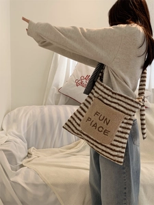 Detail showing plush fuzzy striped tote bag with FUN PLACE embroidery on brown fabric