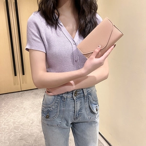 Minimalist beige leather long passport wallet and clutch bag shown with a female model