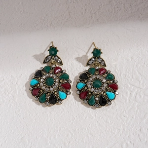 Macro shot of vintage floral stud earrings with multi-colored crystals and rhinestones