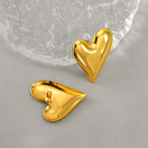 Polished 18K gold plated stainless steel heart stud earrings on decorative ice prop