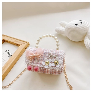 Detail of pink and white tweed girls' bag with pearl handle and bow decoration