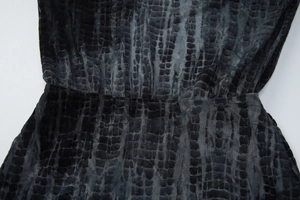 Detailed macro view of dark grey crocodile pattern mesh fabric on waist of mini dress