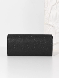 Detailed macro view showing the shimmering black glitter fabric and sleek rectangular flap