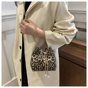 Detail of leopard print bucket bag with gold chain strap and pearl drawstring charms