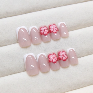 Elegant French blush press-on nails with 3D red floral accents on white tips. High-end.