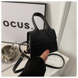 Detail der schwarzen PU-Mini-Handtasche mit goldener Hardware und abnehmbarem Gurt