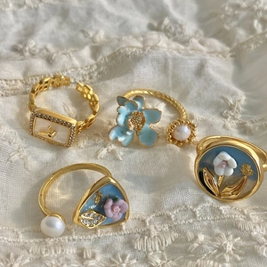 Vintage Baroque pearl rings set with blue and pink enamel flower designs on lace