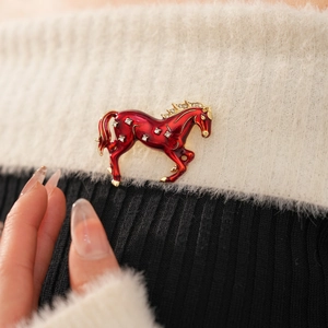 Detailed macro shot of vintage red enamel horse brooch with sparkling rhinestones decoration