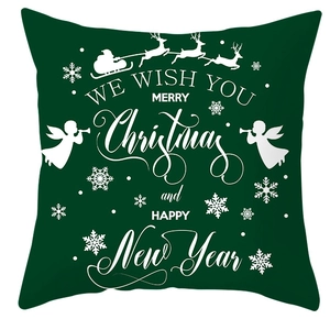 Close-up of green Christmas pillow cover with white festive reindeer and holiday text