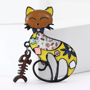Detail of enamel cat brooch with floral patterns and dangling fishbone charm