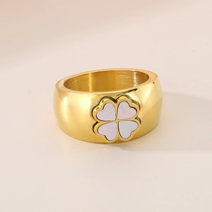 Fashionable 11mm wide gold-plated ring featuring a white clover shell inlay on a beige surface