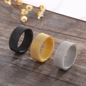 Mesh textured stainless steel wide rings in black gold and silver colors on wood surface