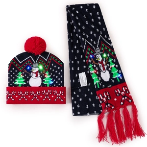 Close-up of LED glowing dark blue Christmas knit hat and scarf set with snowman patterns