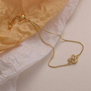 Adjustable gold chain bracelet featuring a sparkling bear pendant with white zircon stones