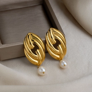 Vintage textured gold earrings with fresh water pearls on an elegant jewelry box display