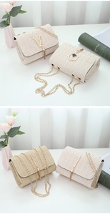 Detail of woven straw crossbody bags with gold chains and various metallic pendants