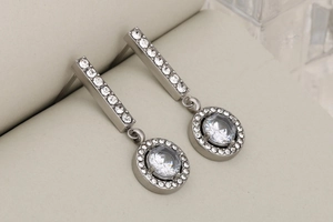 Dettaglio degli orecchini a cerchio in argento con pavé di cristalli e zircone centrale
