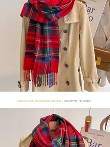 Détail de l'écharpe à carreaux rouges en 100% laine avec franges sur un trench beige