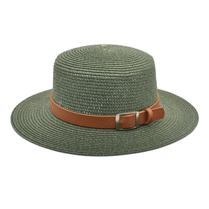 Detalle de sombrero de paja verde con banda de cuero marrón y hebilla metálica fina