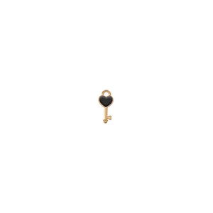 Detailed macro view of a gold-tone key pendant featuring a black enamel heart center