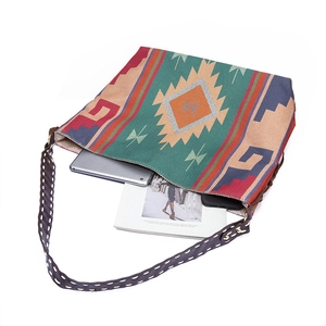 Detail shot of the large woven tote bag showing its spacious capacity with a tablet and phone