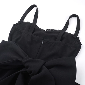 Détail d'une élégante robe noire moulante avec un grand nœud et une fermeture éclair invisible