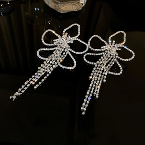 Macro view of silver floral earrings with sparkling diamond fringe and long tassels
