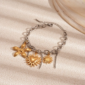 Detail of beach style stainless steel bracelet with sun, flower and heart charms
