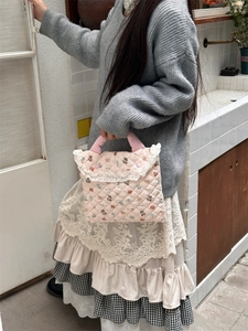 Detailed side view of pink quilted laptop bag with bear print and white lace trim