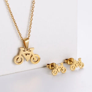 Detailed view of polished golden bicycle pendant necklace and matching stud earrings set