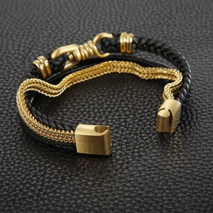 Close-up of black braided leather and gold snake chain bracelet with secure magnet clasp