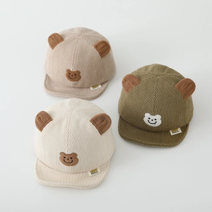 Détail de casquettes en velours côtelé pour bébé avec oreilles d'ours brodées