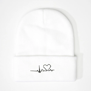 White knit beanie featuring black heartbeat embroidery with a central heart pattern