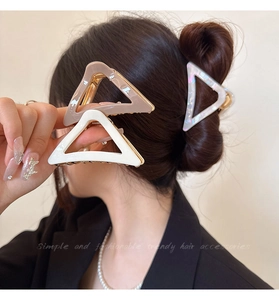 Detailed close-up of hollow triangle hair clips in white, beige, and pearlescent resin