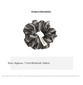 Detail shot of a black and white striped fabric scrunchie measuring 11cm with handmade label