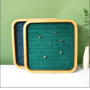 Detailed view of bamboo jewelry tray with emerald green velvet slots for ring display