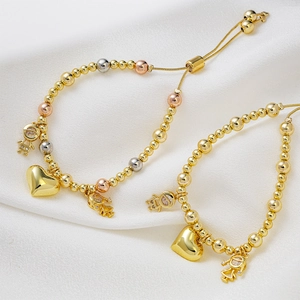 Adjustable beaded bracelets with gold heart and boy girl charms on silk background