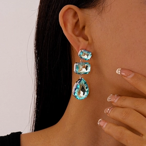 Dettaglio di orecchini a goccia in argento con cristalli blu rettangolari e a forma di goccia