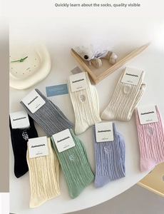 Détail de 8 couleurs de chaussettes en coton peigné avec maille torsadée en tons crème