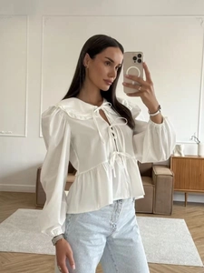 White cotton shirt with ruffle collar and bow tie-up design in a loose-fitting style