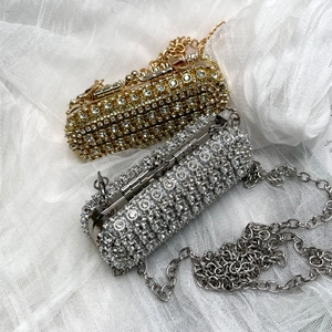 Macro detail of rhinestone lipstick bag in gold and silver finish with chain