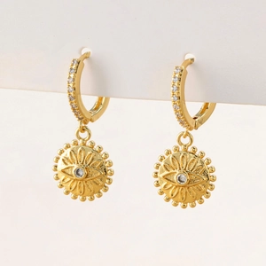 Detailed close-up of golden drop earrings featuring micro-set zircon evil eye charms