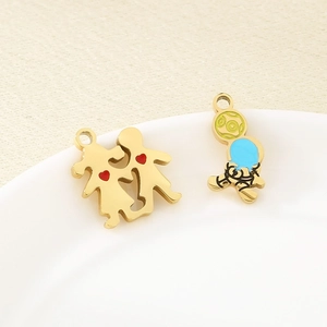 Detail of gold heart and figure charms on white ceramic plate with textured background