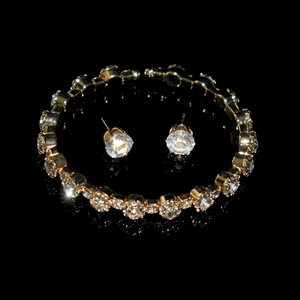 Close-up of gold-plated jewelry set with sparkling round crystal necklaces and stud earrings