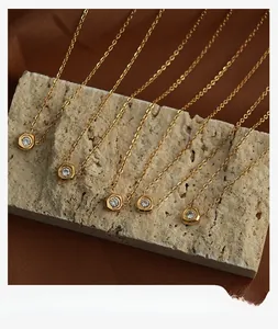 Macro shot of 18K gold-plated hexagonal pendants with zircon inlay on stone surface